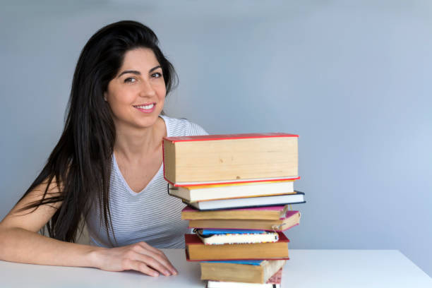 istock Happy smiling student woman reading books 1998353613