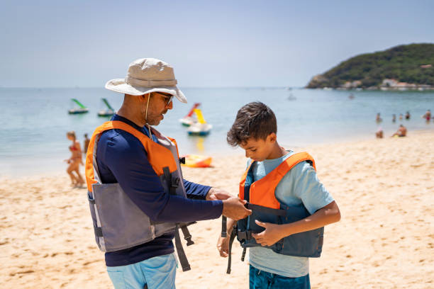 Family wearing life jackets on the beach