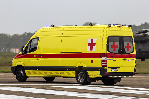 Belgian military ambulance driving over the runway at Kleine-Brogel Airport. Peer, Belgium - September 13, 2014