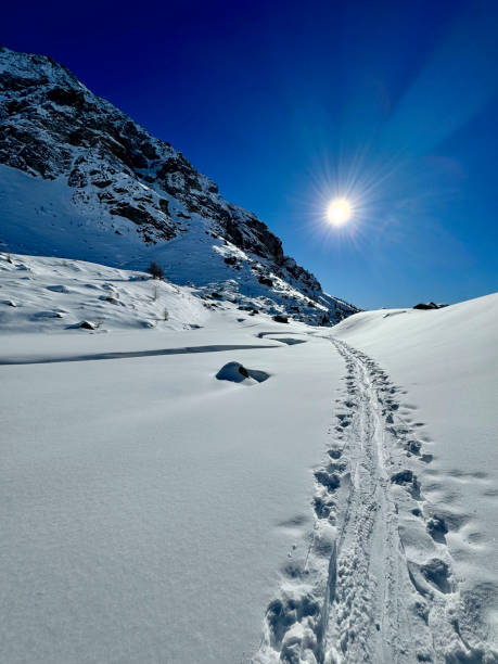 Skialp trail in the snow in the mountains on a sunny winter day stock photo