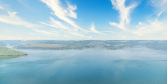 Serene lake view with clear blue skies and fluffy clouds. Beauty of nature. Copy space background. Aerial view panoramic wallpaper.