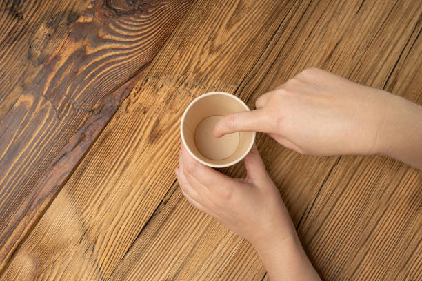istock Hand Holds Cup, Empty Paper Cup in Hands, Coffee Mug, Teacup, Hot Beverage Mockup, Cup in Arms 1998435830