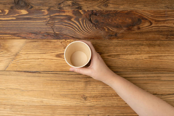 istock Hand Holds Cup, Empty Paper Cup in Hands, Coffee Mug, Teacup, Hot Beverage Mockup, Cup in Arms 1998435832