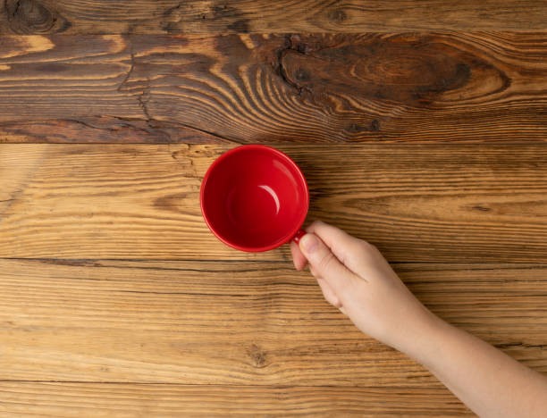istock Hand Holds Cup, Empty Red Cup in Hands, Coffee Mug, Teacup, Hot Beverage Mockup 1998435835