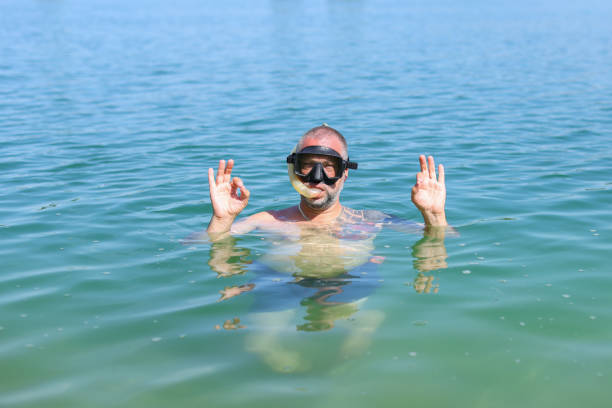 High angle view of girl taking googles out in swimming pool in hot sunny day