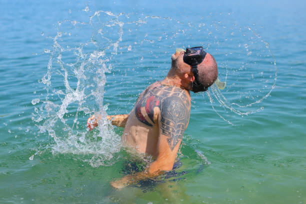 diver in a mask emerges from the sea