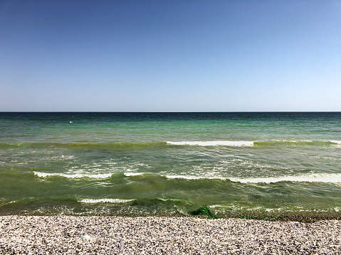 Sea green aquamarine waves line sunny seashell beach. wave ocean foam. Natural background sky. Template space pattern wallpaper mockup. Summer background Black sea waves marine shells pebble beach