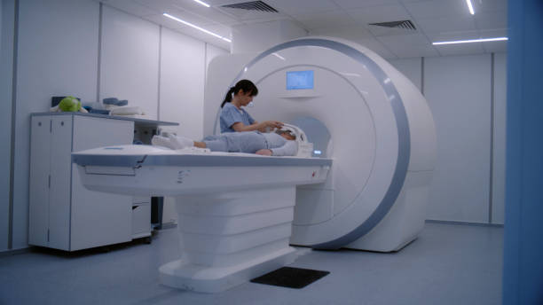 istock Female radiologist controls MRI or CT scan machine for female patient 1998504871
