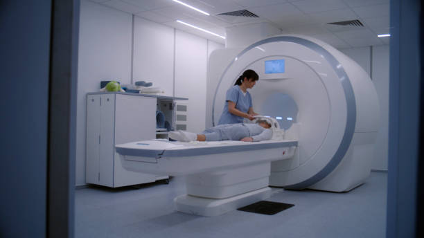 istock Female radiologist controls MRI or CT scan machine for female patient 1998513563