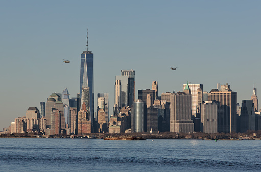 military style helicopters flying over downtown manhattan skyline at sunset footage (air force presidential escort chopper, double blade) lower nyc waterfront with helicopter