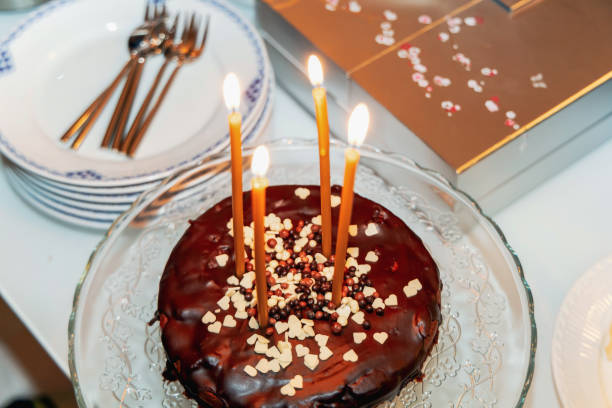 istock Chocolate cake with four burning candles 1998534081
