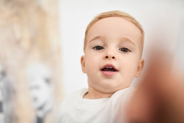Portrait of a little girl standing in front of a mirror.