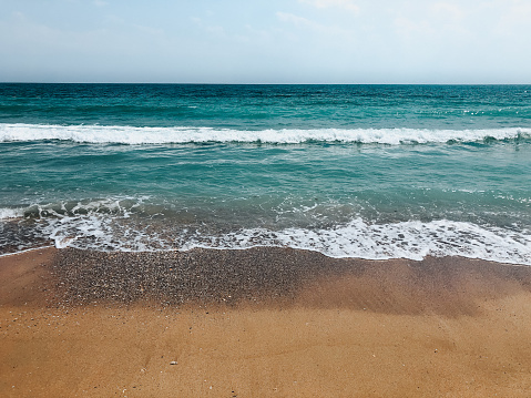 Sea blue aquamarine waves line sunny sand beach. Soft wave of ocean foam. Natural background sky. Template free space pattern wallpaper mockup. Summer background Black sea waves marine beach