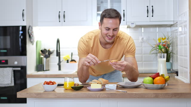 Portrait of an young man having an breakfast in the kitchen