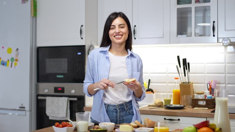 Portrait of an young woman having an breakfast in the kitchen
