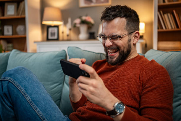 istock A man playing video games on his smartphone, visibly excited and happy because he is winning, rejoices 1998643241