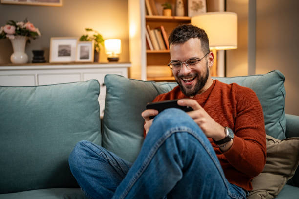 istock A man playing video games on his smartphone, visibly excited and happy because he is winning, rejoices 1998643765