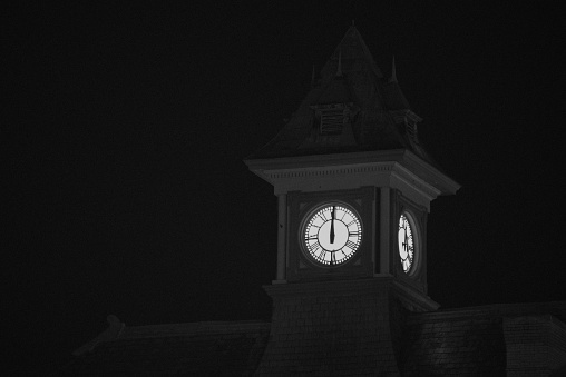 Church clock tower strikes midnight on new years eve.