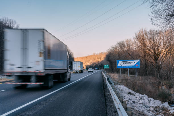 semi trucks driving along i-65 north by the tennessee welcomes you" sign on the tennessee/alabama border in winter - tennessee sign welcome sign greeting 뉴스 사진 이미지