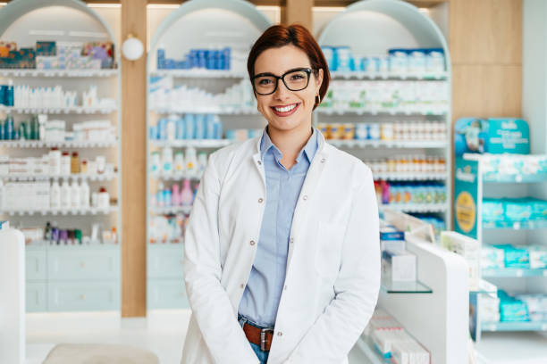 glückliche apothekerin bei der arbeit - pharmacy pharmacist smiling pill stock-fotos und bilder
