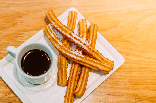 Churros sprinkled with powdered sugar set, on gray background