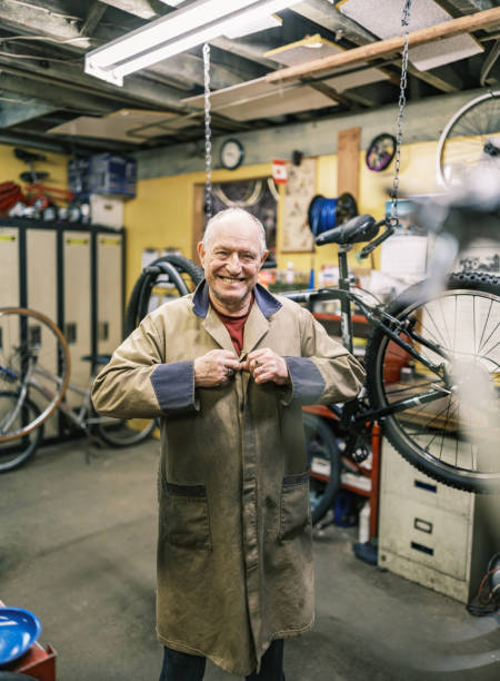 istock Senior man getting ready to work in his bicycle shop 1998700883
