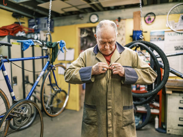 istock Senior man getting ready to work in his bicycle shop 1998700943