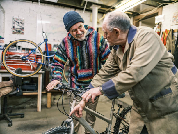 istock Two Senior men talking in bicycle shop 1998726542