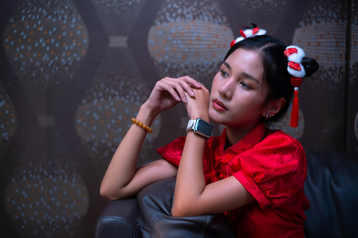 A beautiful woman wearing a red cheongsam sat on the sofa and had a solemn expression. Very cool from being a mafia gangster.