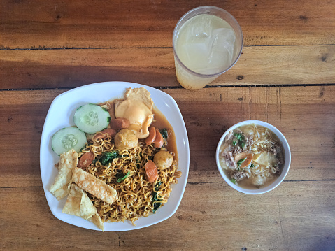 Serving Of Nyemek Fried Noodles Or Mie Nyemek And Soto Daging Sapi With Lime Iced. Mi Nyemek Goreng Dan Es Jeruk Nipis. Food And Drink Menu. Top View.