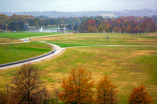The National Mall in autumn with the Lincoln Memorial visible over the treeline and the World War II Memorial with beautiful fall foliage