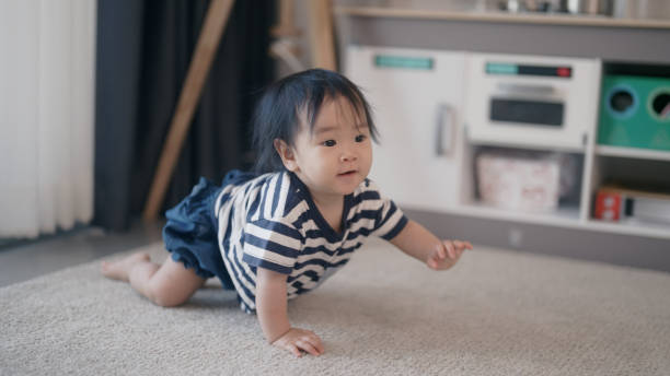 istock Baby girl crawling on floor at home 1998865636