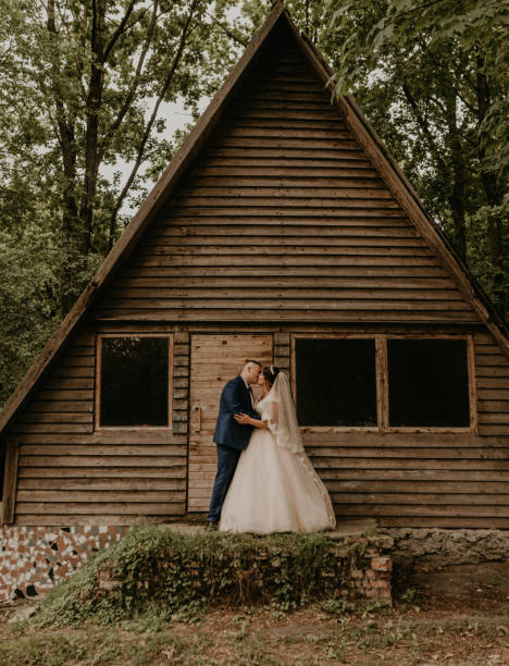 istock Newlyweds hugging standing near wooden small triangular house 1998871744
