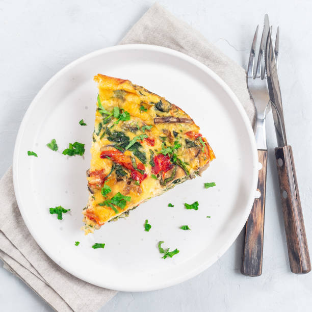 istock Piece of egg frittata with spinach, roasted peppers, mushrooms, cheese, top view, square format 1998886702
