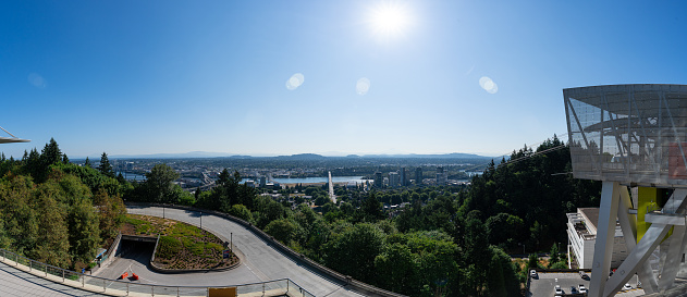 A panorama of the Portland Aerial Tram with the Portland Skyline and Mt. Hood in the background on a clear sunny summer day as viewed from the Oregon Health and Science University.