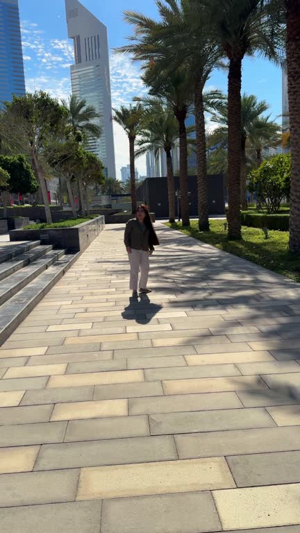 happy girl with long hair spins in the city with a view of high-rise buildings. High quality FullHD footage