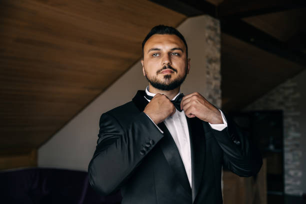 istock pensive man straightens his tie. get ready for the wedding. 1998903557