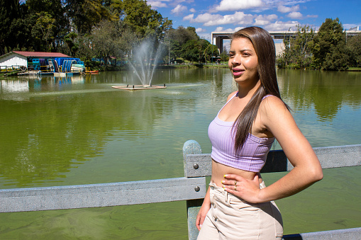 Beautiful young woman posing in a public park
