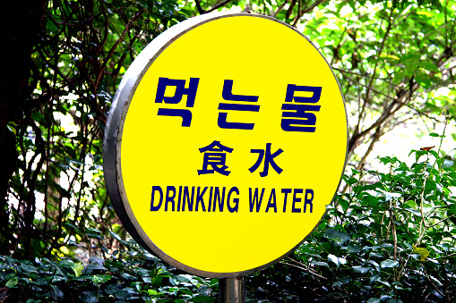 Rótulo que dice agua potable, en los idiomas coreano e inglés