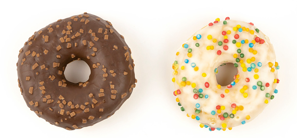 Two different donuts on a light background. The concept of sweet pastries
