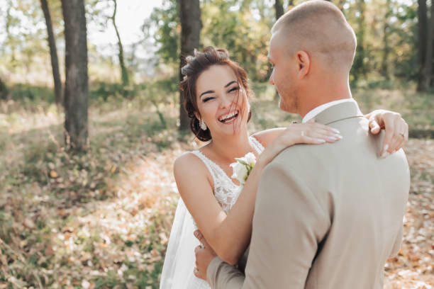 istock The bride and groom stand in the forest hugging, she smiles sincerely. 1999051410