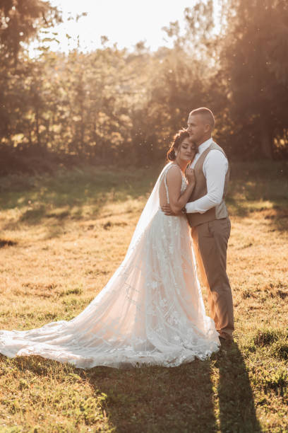istock The bride and groom are standing in a beautiful forest, in beautiful light, hugging 1999052502