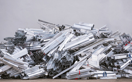 Pile of many aluminum waste construction material scraps on the ground for recycling