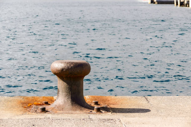 istock Old steel mooring bollard pole on a pier, rusty mooring 1999054198