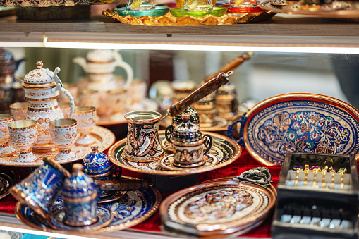 Array of colorful traditional Turkish ceramics and ornate metal teapots on display at a souvenir shop in Istanbul, Turkey.
