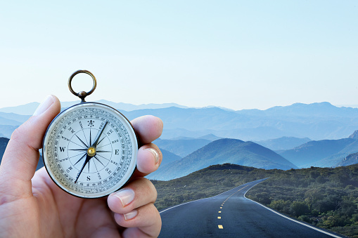 Compass Dpw Hand Holding Compass With Winding Road In Background Stock Photo ...