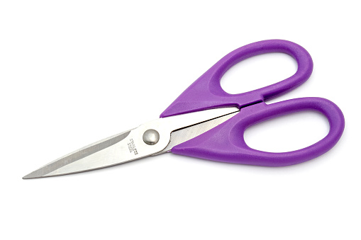 Purple pair of scissors isolated on white background