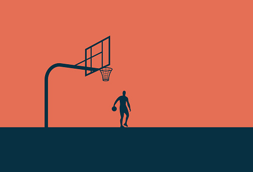 Man playing basketball at sunset