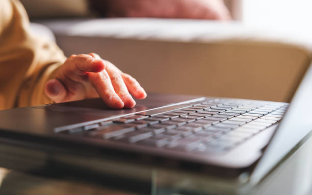 istock Closeup image of a hand working and touching on laptop computer touchpad at home 1999219326