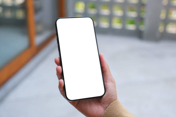 istock Mockup image of a woman holding mobile phone with blank desktop white screen 1999219329